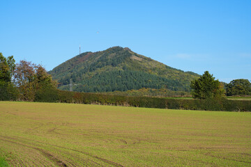 View of the Wrekin hill near Telford in Shropshire UK overlooking rural fields with Autumn colours on the trees