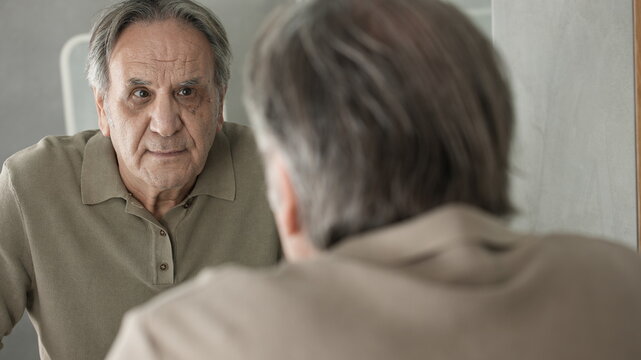 Old Man Looking At His Face In The Mirror	