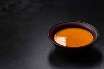 Delicious hot pumpkin and carrot soup puree with spices and herbs