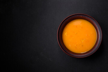 Delicious hot pumpkin and carrot soup puree with spices and herbs