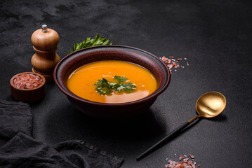 Delicious hot pumpkin and carrot soup puree with spices and herbs