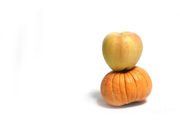 a pile of pumpkin and an apple against white background