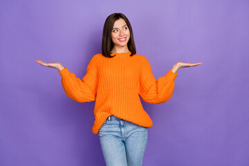 Photo portrait of lovely young woman hands scales look empty space wear trendy knitwear orange...