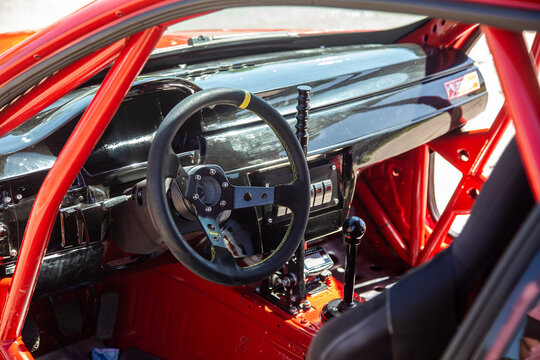 Salon of a fast racing car. Round small steering wheel. Dashboard. Security frame. Beautiful racing car interior.