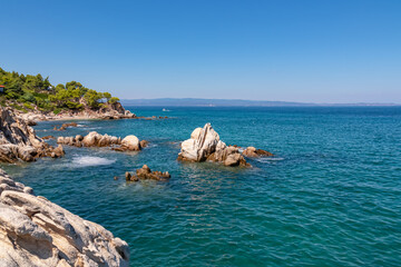 Panoramic view on calm Fava sand beach near Vourvourou, Greek peninsula Sithonia, Chalkidiki (Halkidiki), Greece, Europe. Summer vacation at Aegean Mediterranean Sea. Unique natural rock formations