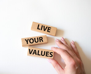 Live your values symbol. Concept words Live your values on wooden blocks. Beautiful red background. Businessman hand. Business and Live your values concept. Copy space.