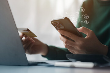 Woman holding a credit card, she uses a credit card to pay for goods and services online, the concept of using a credit card for online shopping, ordering goods and services on the website.