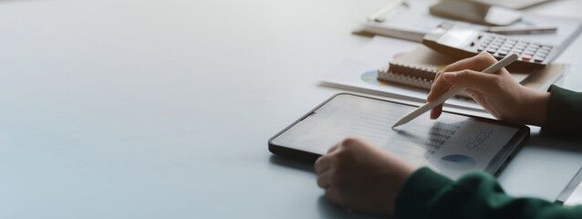 Business men are looking at the company's financial documents on tablets to analyze problems and...