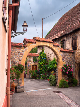 Rouffach, France - October 11, 2022: Vertical photo of the traditional courtyard arch of an old house in Rouffach, Alsace, France