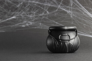 fake witch's cauldron, on a black background with cobwebs.  halloween concept