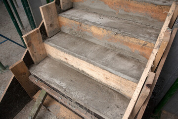 Builders made stair structures from wooden planks and poured concrete, building a modern house