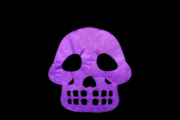 Obraz premium Colored papel picado for an offering for the Mexican tradition of the Day of the Dead and All Saints with skull shapes on a black background
