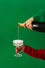 Abstract background of Christmas party, Champagne is poured from bottle into glass in female hand