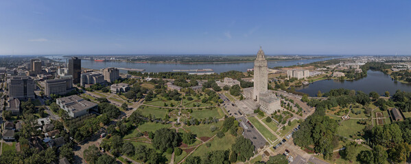 Baton Rouge State Capitol Louisiana city Mississippi River bridge levee tug boats mid angle wide shot afternoon