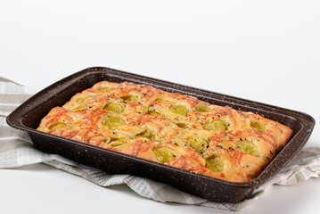 Traditional Italian focaccia bread with physalis and cheese. Fruit pie in a baking dish on a white background