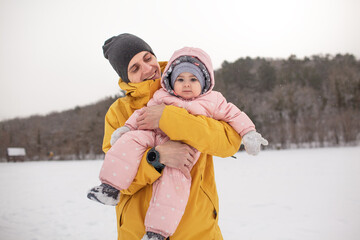 Happy father play and have fun woth baby. Man holding the female toddler in the hands and laughing on a cold winter day