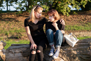 A woman hugs teenage daughter and listens her, daughter tells mother about teenage problems,...