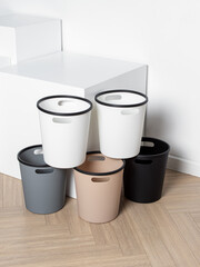 Multicolored plastic buckets. Trash cans for kitchen, living room, bathroom or hallway on white background. Vertical