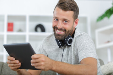 man in phones with tablet pc listening to music