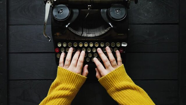 Hand of young woman writer on old typewriter