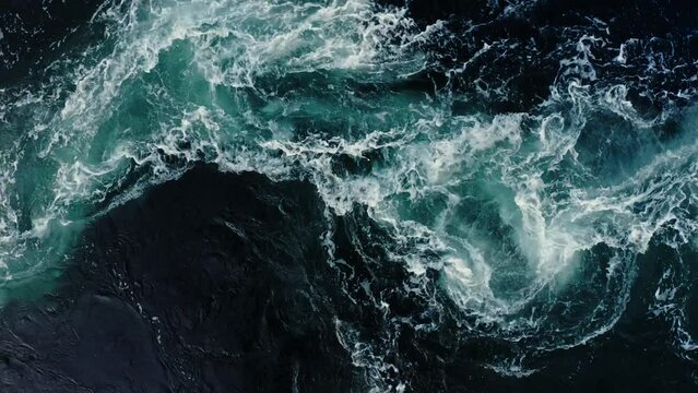 Waves of water of the river and the sea meet each other during high tide and low tide. Deep blue stormy sea water surface with white foam and waves pattern, background texture