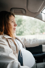 Calm pregnant redhead woman driving.