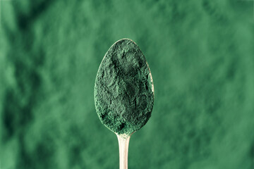 Spirulina algae powder on a spoon, top view