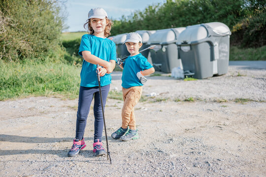 Boys with garbage tongs in countryside