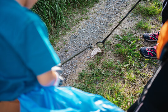 Faceless volunteers picking garbage from ground