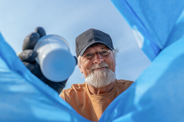 Senior man throwing garbage into bag