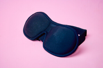 black eye mask for sleeping on a pink background