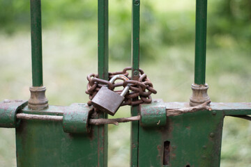 candado oxidado que cierra una antigua reja verde