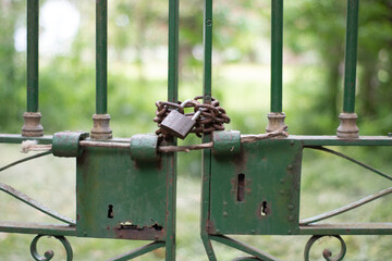 candado oxidado que cierra una antigua reja verde