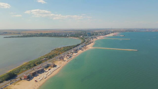 Aerial video taken from a drone at Eforie beach with Techirghiol lake on the left side of the beach and the Black sea on the right side. A patch of land between sea and lake.