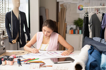 Young fashion designer woman drawing sketches pattern clothes. female tailor thinking and design idea concept, dressmaker working in workshop studio desk. SME small business owner self-employed.