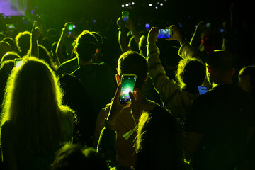 People with mobile phones at a concert. Hands with mobile phone. public at a concert takes photos with the mobile.