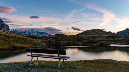 Obraz premium sunset at Tannensee an alpine lake in the Swiss alps with a bench in front