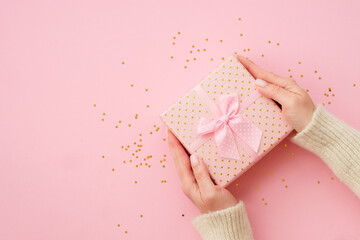 Woman giving present box on pink background. Boxing day. Top view with copy space.