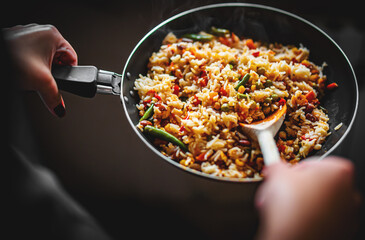 cooking tasty rice and vegetable mix with corn, pea, beans in pan on kitchen
