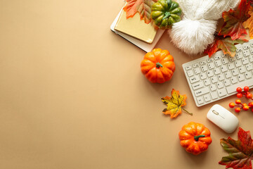 Autumn office workspace. Autumn flat lay background. Keyboard, laptop with autumn cloth and fall...