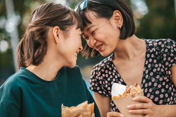 Young couple enjoying street food and looking happy and in love