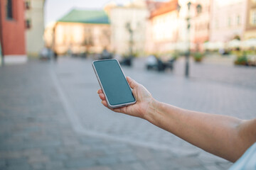 Close up of women's hands holding cell telephone with blank copy space scree for your advertising text message or promotional content, hipster girl watching video on mobile phone 
