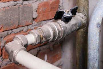 Black brass ball shut-off valves on water supply pipeline in the house, plumbing and construction concept