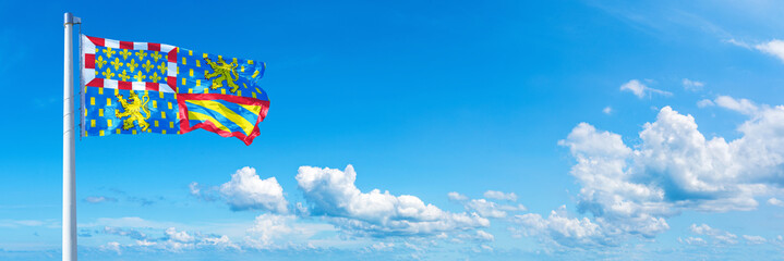 Obraz na płótnie Canvas Bourgogne-Franche-Comté, France - flag waving on a blue sky in beautiful clouds - Horizontal banner