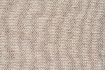 Light beige woolen knitted fabric texture. Macro.