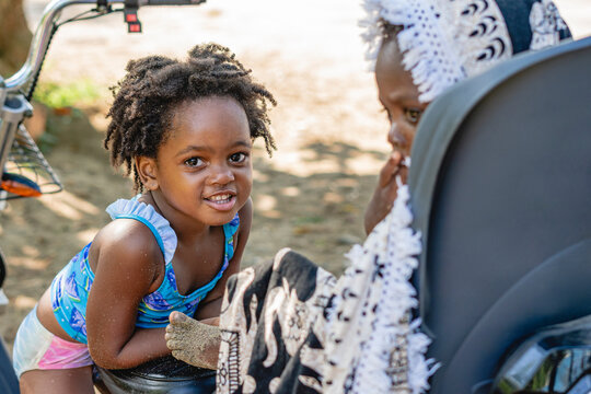 Imagen horizontal de una ni&ntilde;a afroamericana junto a su peque&ntilde;o hermano al aire libre en un hermoso d&iacute;a de verano. 