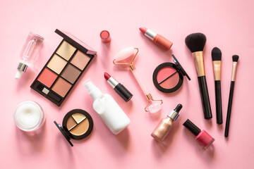 Makeup cosmetic products on pink background. Cream, lipstick, shadow and brushes. Flat lay image...