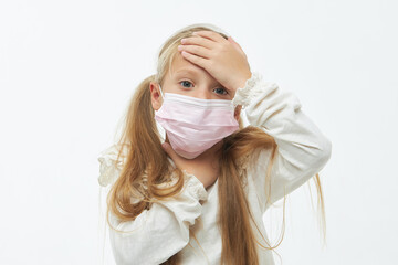 Cute ill child girl in a protective face mask. holding hands on neck. Protection against flu and cold diseases during a pandemic. White isolated background