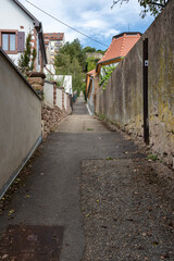Obernai, France - 09 05 2022: View of an uphill street with steps to join terraced vines and the National Memorial of Forced Incorporated