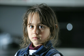 Young girl 6-7 years old looks into the camera